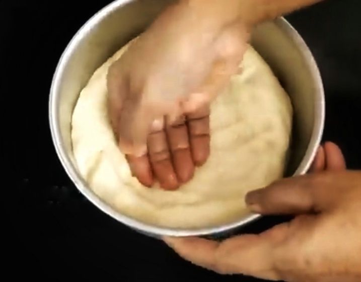 Step 1.1: Place the dough in the tin and gently flatten it using your hand, slightly pulling the sides to create a small bowl shape