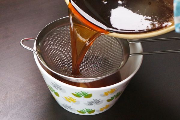 Step 2.1: Strain the jaggery syrup through a metal strainer to remove impurities