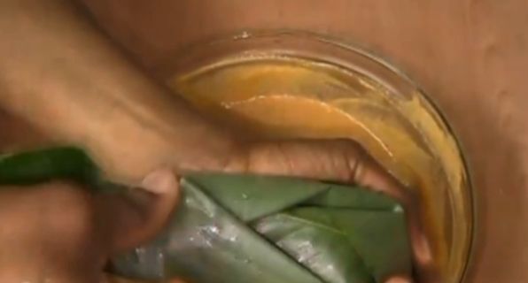 Step 5.5: Begin folding the Uma leaves and scoop the plantain moi moi mixture into each leaf wrap, one by one