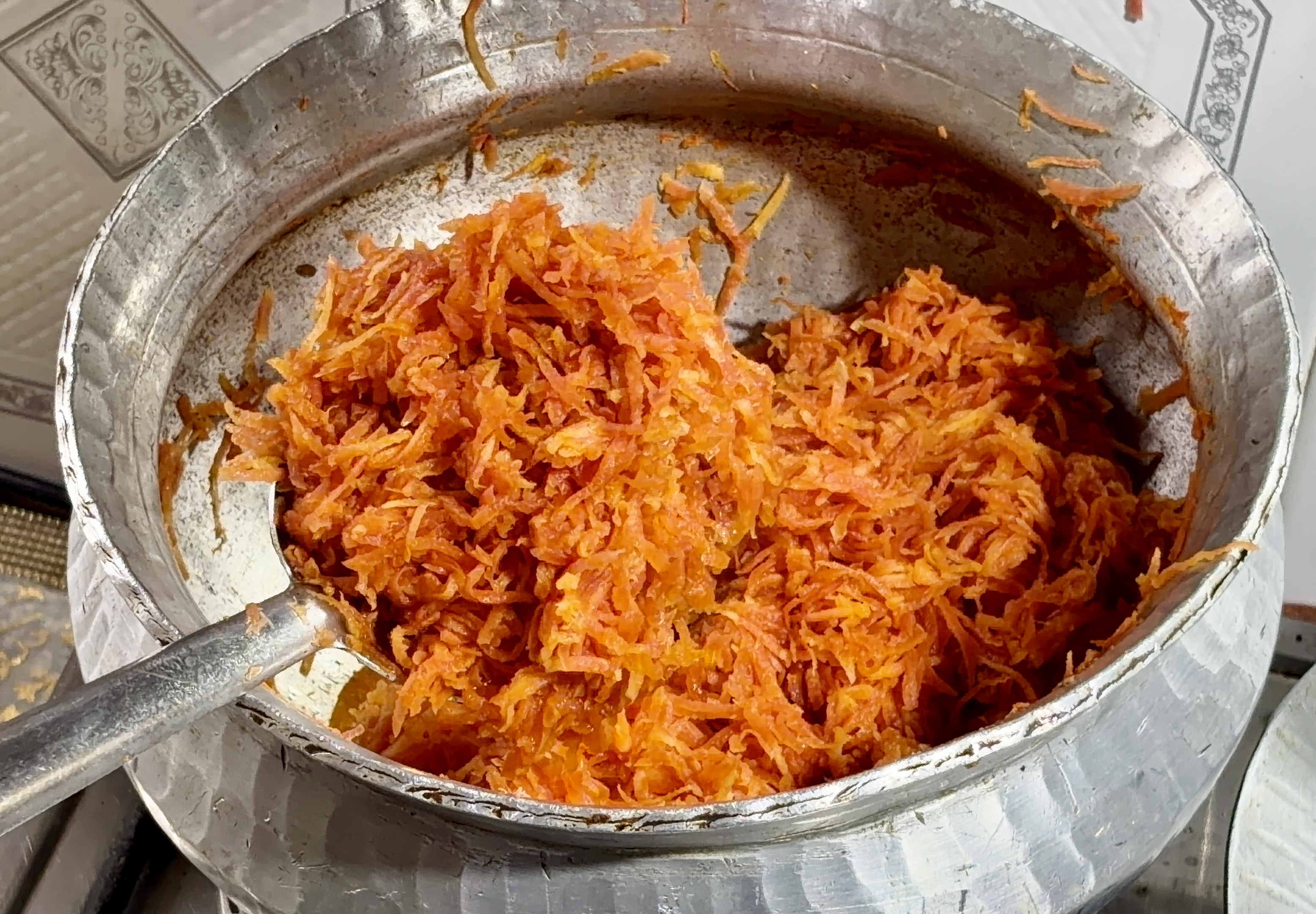 Step 1.2: In the same pan, add the grated carrots