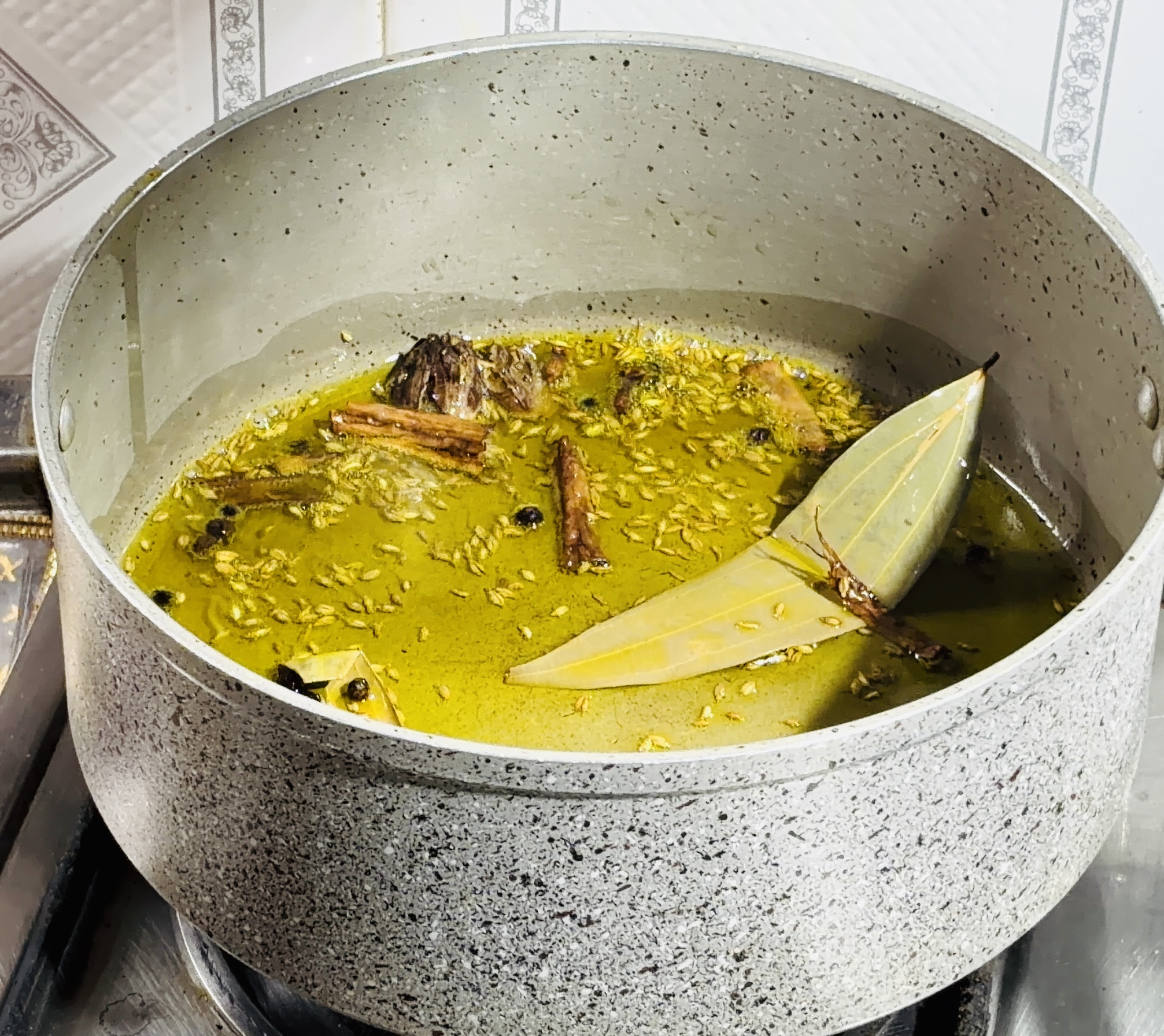 Step 3.2: Lower the heat, and add cumin seeds, cinnamon, bay leaves, peppercorns, black cardamom, and cloves