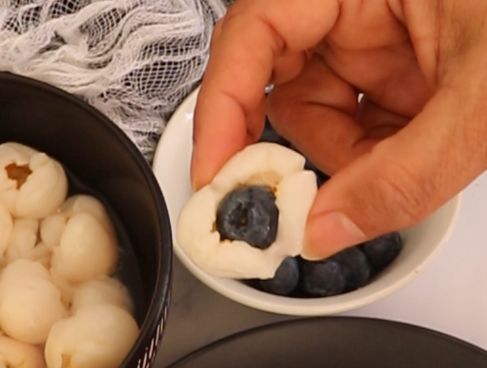 Step 1.1: Prepare the 'eyeballs' by inserting a blueberry into the center of each lychee