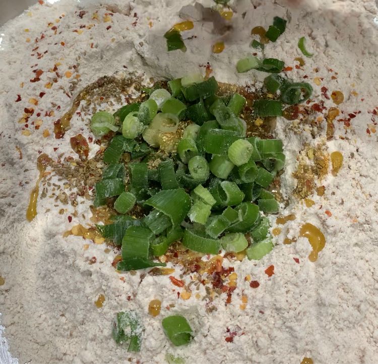 Step 1.1: Add the finely chopped green part of the shallots to the bowl and mix them well with the flour mixture