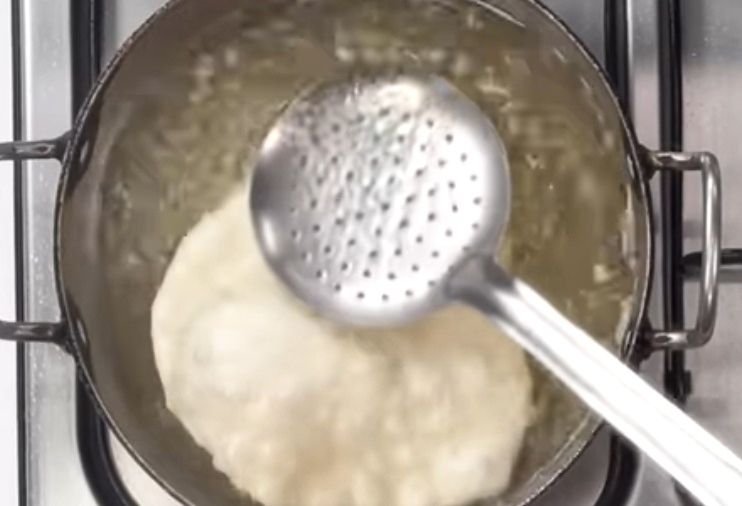 Step 1.2: Press lightly with a slotted spoon to help it puff up