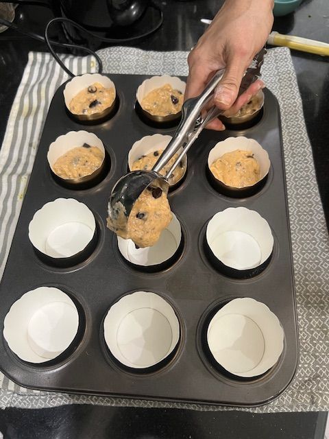 Step 6.1: Spoon the batter into the prepared muffin tin, filling each cup about ¾ of the way