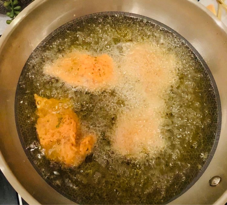 Step 4.1: Carefully place the marinated fish into the hot oil in batches