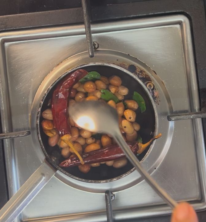 Step 2.1: Add whole red chillies, curry leaves, and peanuts, and sauté until the peanuts are roasted