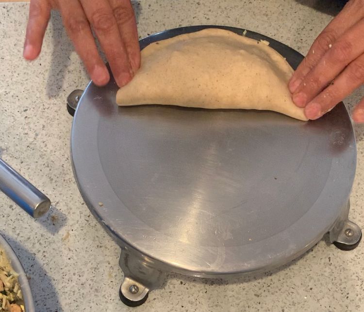 Step 2.2: Add a layer of cheese or a cheese slice onto the mixture and fold the remaining half of the dough over the filling