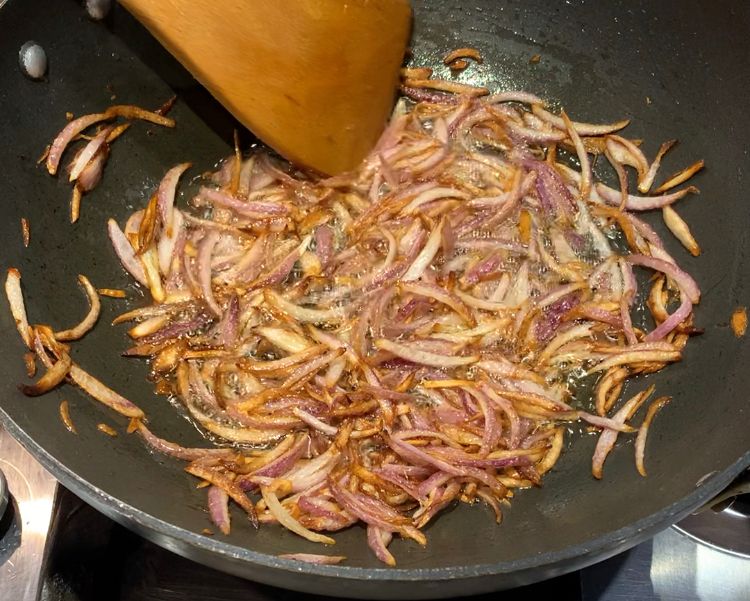 Step 1.1: Heat oil in a heavy-bottomed wok and add the sliced onions
