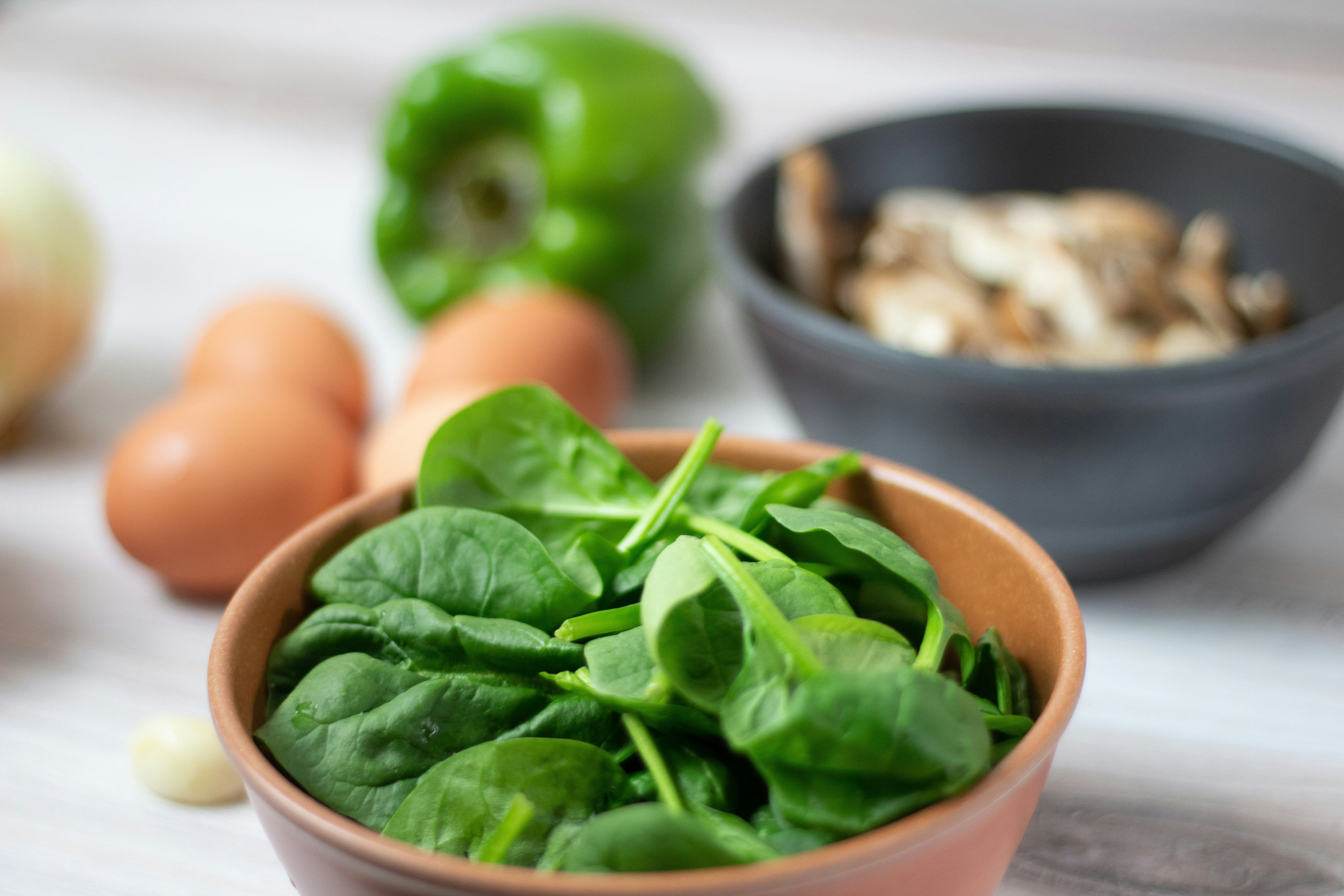 A bunch of spinach leaves bundled together on a countertop.