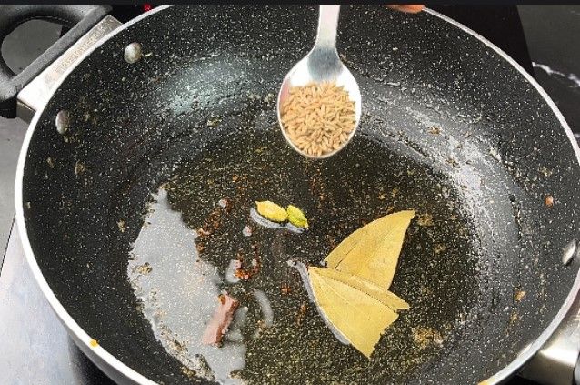 Step 2.5: In a large kadai, heat oil and sauté cumin, cinnamon, cardamom pods, and bay leaf