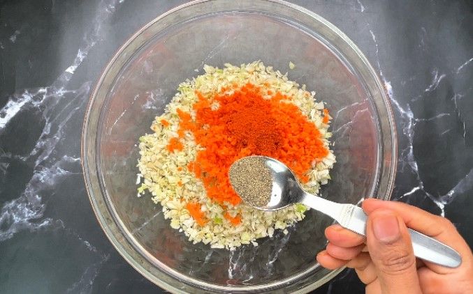 Step 1.4: In a large bowl, combine finely chopped cabbage, grated carrot, chili powder, pepper powder, salt, and ginger garlic paste