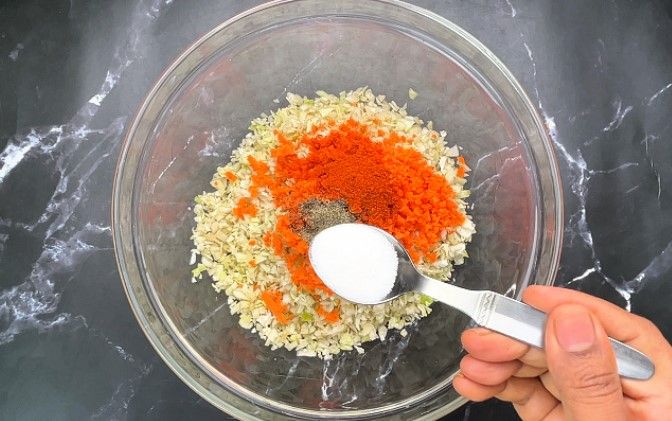 Step 1.5: In a large bowl, combine finely chopped cabbage, grated carrot, chili powder, pepper powder, salt, and ginger garlic paste