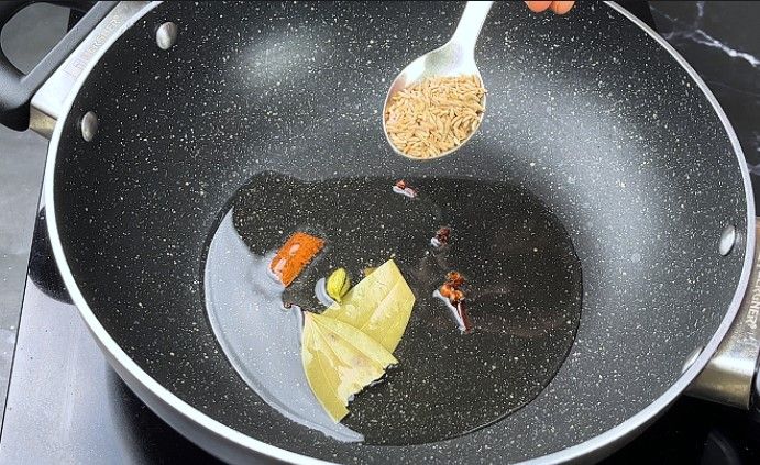 Step 3.5: Add the bay leaf, cinnamon stick, cloves, green cardamom, and cumin seeds