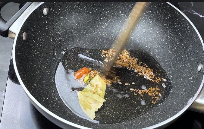 Step 3.6: Add the bay leaf, cinnamon stick, cloves, green cardamom, and cumin seeds