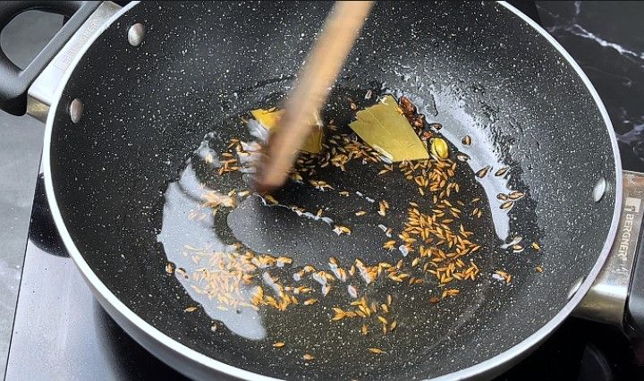 Step 3.7: Add the bay leaf, cinnamon stick, cloves, green cardamom, and cumin seeds