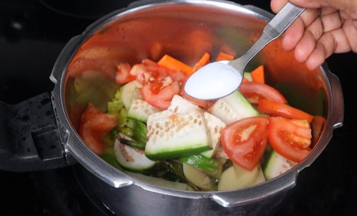Step 3.5: Add the chopped brinjal, potato, bottle gourd, carrot, tomato slices, and salt Stir fry for a few minutes