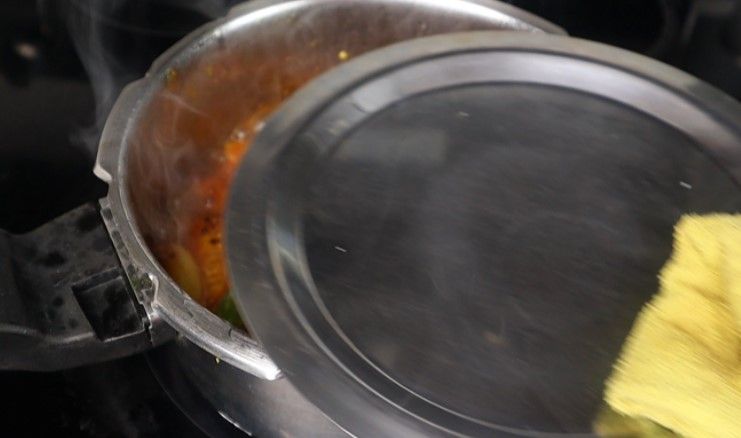 Step 3.4: Pour in the tamarind extract, cover with a lid, and cook for 2 minutes on low flame