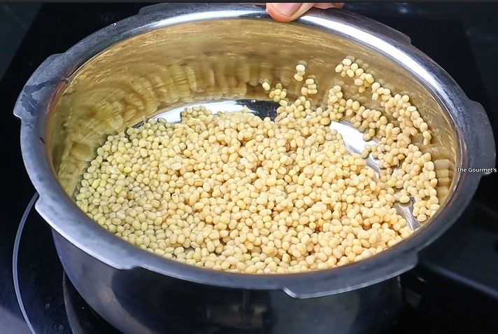 Step 1.4: Take 1/2 cup of urad dal, rinse well, and pressure cook it with sufficient water for 3-4 whistles or until soft and mushy
