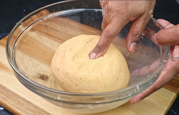 Step 2.3: Gradually add water and knead to form a soft but firm dough