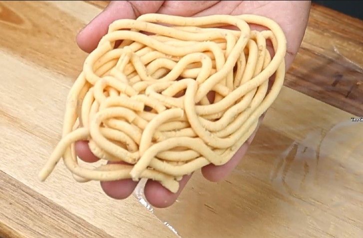 Step 3.5: Press the dough into spiral shapes (traditional murukku shapes) on a greased plate or [parchment paper](https://amzn