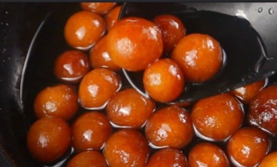 Step 2.4: Transfer the fried jamuns into the warm sugar syrup