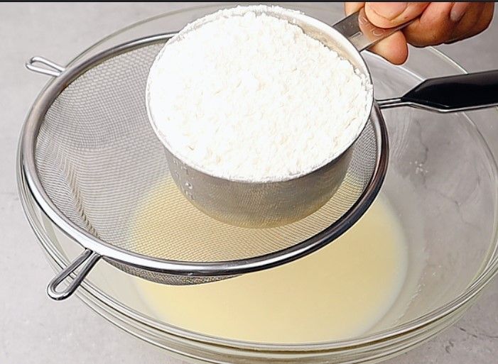 Step 1.2: Place a sieve over the bowl and add all-purpose flour, baking powder, baking soda, and salt