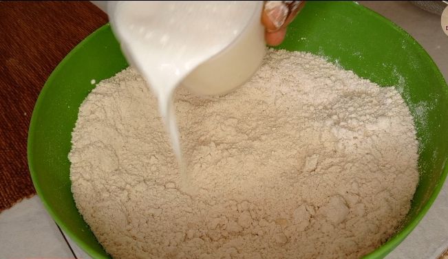 Step 1.2: Gradually add milk to the dry ingredients and knead until a soft dough forms
