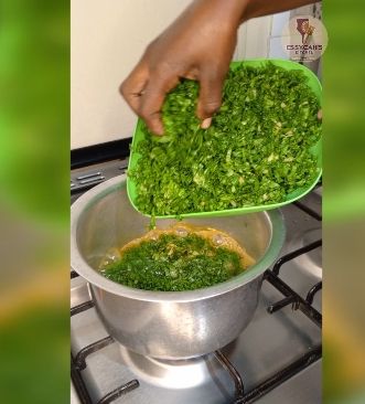 Step 2.2: In a large pot over medium heat, bring water to boil and add in soda ash, jute mallow and later in add spinach leaves cook until they begin to wilt