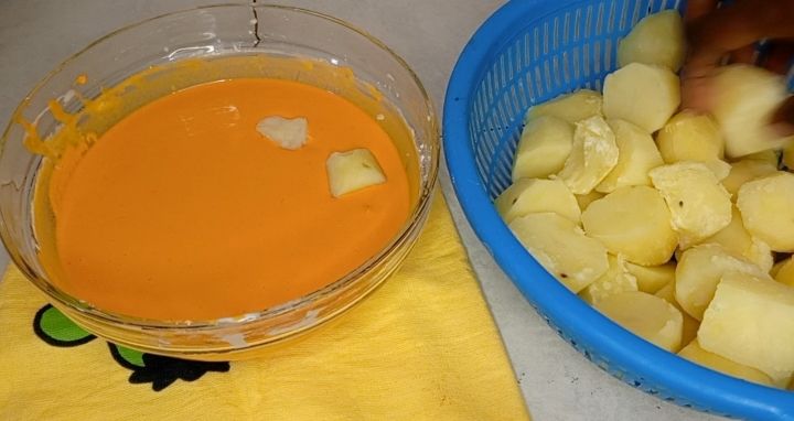 Step 1.4: From the boiled potatoes, cut them into small pieces and deep them inside the prepared batter and toss them gently to coat evenly