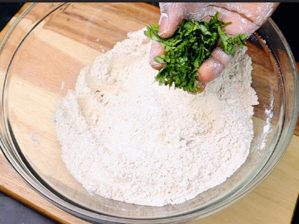 Step 2.1: Add the mashed potatoes and chopped coriander leaves to the flour mixture and mix thoroughly