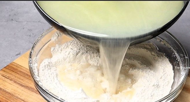 Step 1.1: Pour the hot water mixture into the dry ingredients, stirring continuously with a spatula