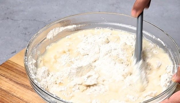 Step 1.2: Pour the hot water mixture into the dry ingredients, stirring continuously with a spatula