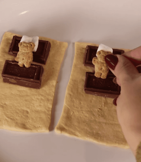 Step 1.1: Add a mini marshmallow on top of the chocolate, then place a Teddy Graham on it to act as a pillow