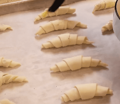 Step 1.1: Bend the edges to form a crescent shape and brush with egg wash