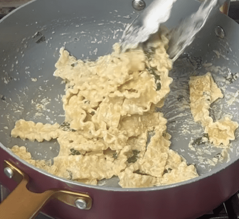 Step 1.1: Toss the cooked pasta into the sauce and add a splash of the reserved pasta water to loosen the sauce if needed
