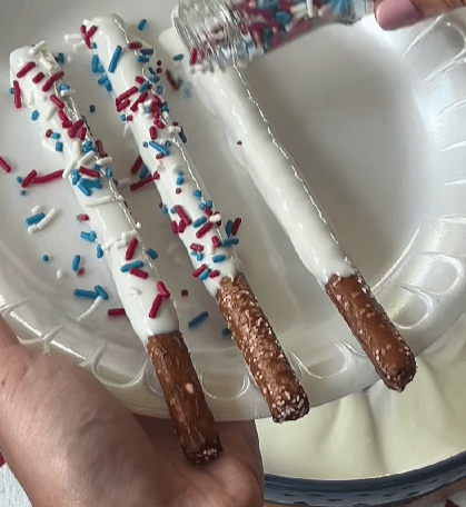 Step 1.2: Sprinkle the coated pretzels with patriotic sprinkles and drizzle additional melted candy for decoration