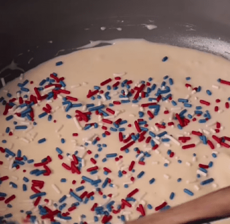 Step 1.1: Stir in the vanilla extract, sea salt, and patriotic sprinkles into the melted white chocolate mixture