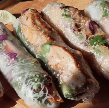 Step 4.2: Layer noodles, veggies, and herbs just off the center of the rice paper, then add chicken