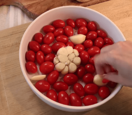 Step 1.1: Combine cherry tomatoes, garlic (whole head and extra cloves), salt, pepper, garlic powder, red pepper flakes, parsley, and olive oil in a baking dish