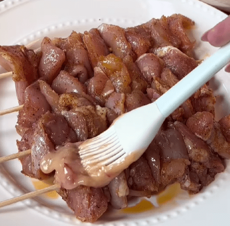 Step 1.1: Generously coat both sides of the chicken skewers with the bang bang sauce