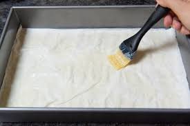 Step 3.1: Layer 5 sheets of phyllo dough in the dish, brushing each sheet with melted butter before adding the next