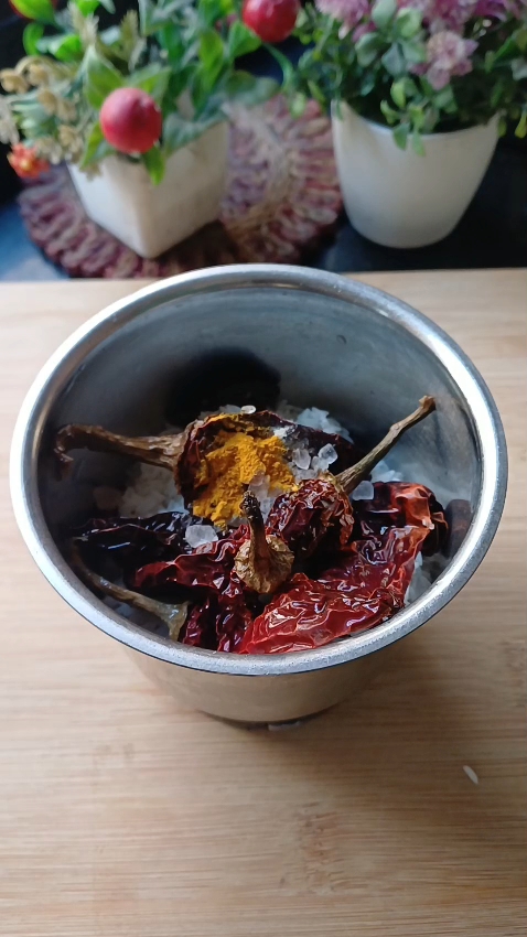 Step 1.1: In a mixie jar, blend soaked rice, lashmiri dry red chillies, tamarind, rock salt, and turmeric powder into a fine paste