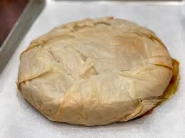 Step 3.1: Fold the overhanging phyllo dough over the filling, then layer another 5 sheets of phyllo on top, again brushing each with melted butter