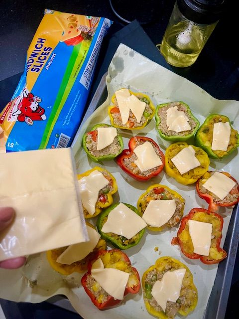 Step 6.1: With 5 minutes of baking left, top each pepper with a cheese slice piece