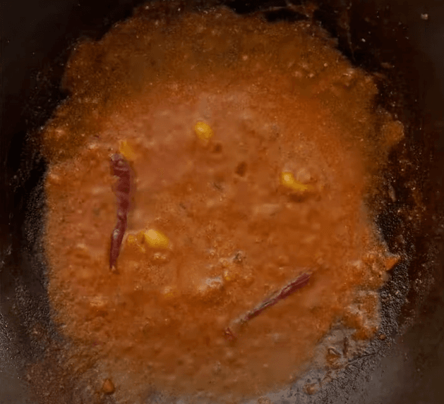 Step 2.1: Reduce the flame and add Kashmiri red chili powder along with a pinch of garam masala, stirring gently to blend the spices