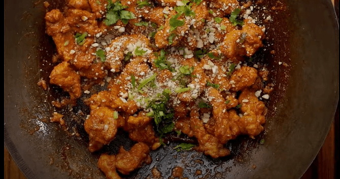 Step 3.1: Add the fried chicken pieces to the sauce, mixing thoroughly so each piece is well-coated with the spicy, tangy sauce