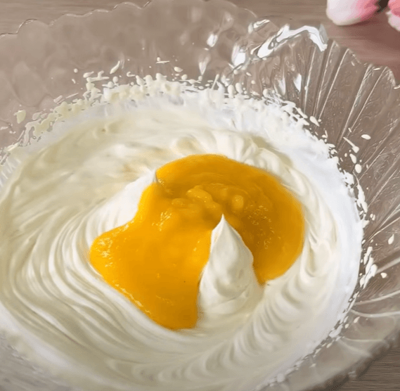 Step 1.1: Fold in the finely chopped mango into the whipped cream