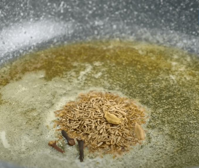 Step 2.1: Add cumin seeds, green cardamom, cloves, and cinnamon sticks