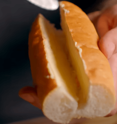 Step 1.1: To assemble the roll, cut open the hot dog bun and apply soft butter